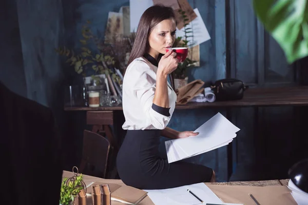 Молодая красивая женщина работает с чашкой кофе — стоковое фото