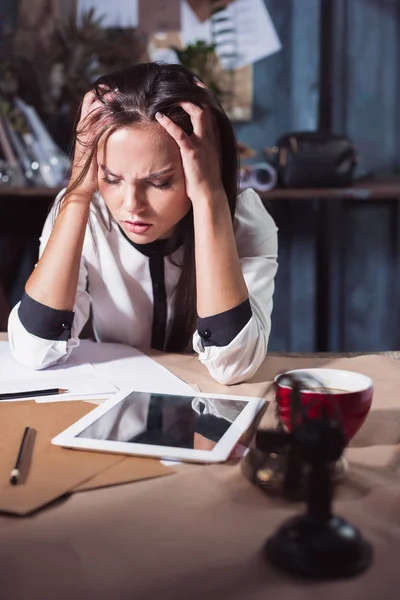 Молода розчарована жінка працює за офісним столом перед ноутбуком — стокове фото