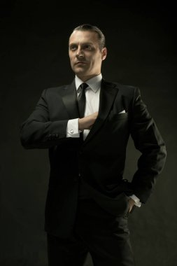 Koyu arka plan üzerinde siyah elbiseli çekici bir adam