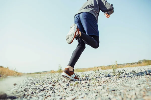 Olahraga lari. Seorang pelari berlari keluar ruangan di alam yang indah. Fit muscular male athlete training trail running for marathon run. — Stok Foto