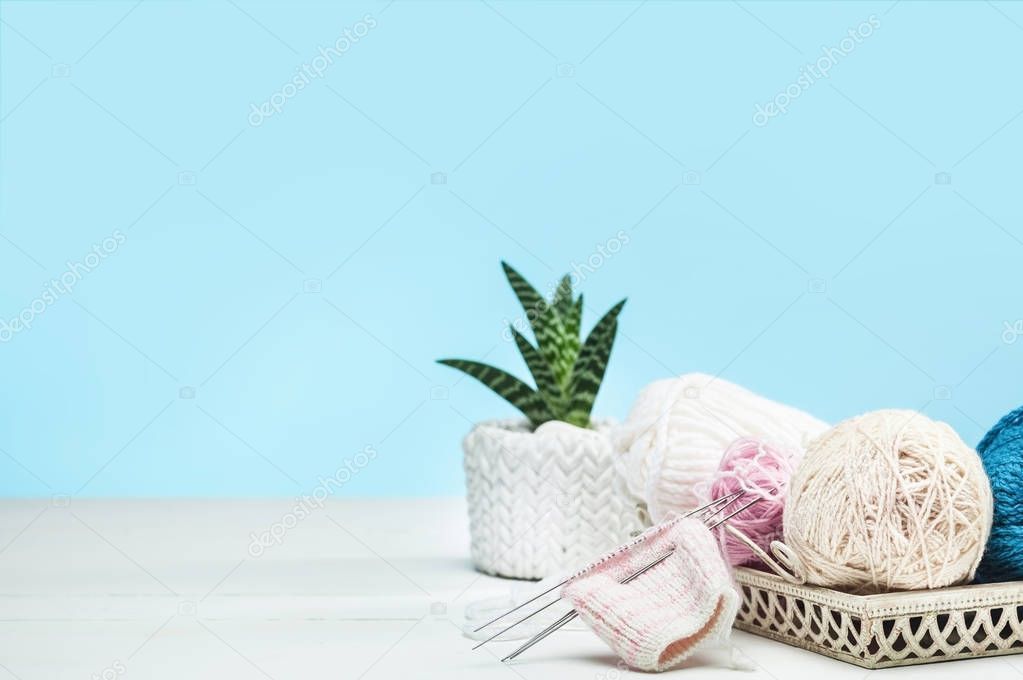 The balls of wool on white wooden background