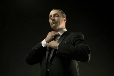 Koyu arka plan üzerinde siyah elbiseli çekici bir adam