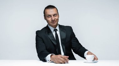 Beyaz arka planda siyah elbiseli çekici bir adam