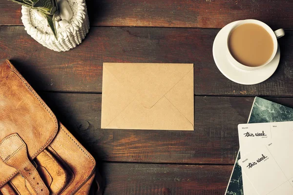 Envelope de papel artesanal aberto, folhas de outono e café em mesa de madeira — Fotografia de Stock