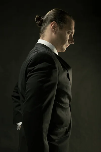 Atraktivní muž v černém obleku na tmavém pozadí — Stock fotografie