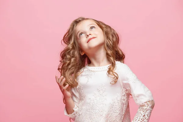 Das schöne kleine Mädchen im Kleid steht und posiert vor weißem Hintergrund — Stockfoto