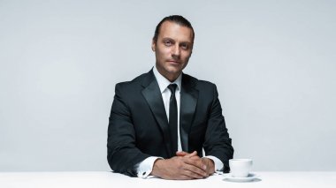 Beyaz arka planda siyah elbiseli çekici bir adam