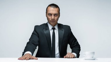 Beyaz arka planda siyah elbiseli çekici bir adam