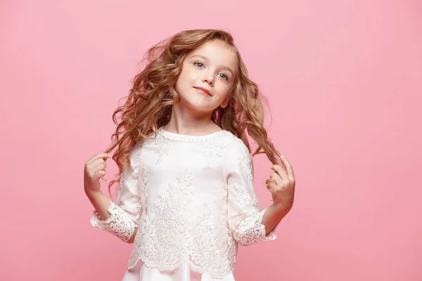 Красивая маленькая девочка в платье стоя и позируя на белом фоне — стоковое фото