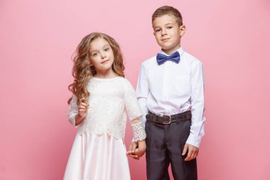 Oğlan ve kız Studio pembe bir arka plan üzerinde ayakta