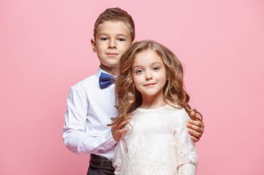 Oğlan ve kız Studio pembe bir arka plan üzerinde ayakta