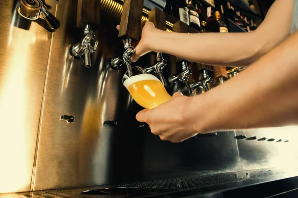 Mano de cantinero vertiendo una gran cerveza lager en el grifo . — Foto de Stock