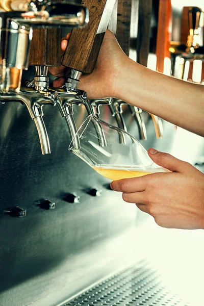 Mão do barman derramando uma grande cerveja lager na torneira . — Fotografia de Stock