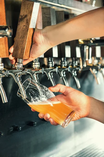 Mão do barman derramando uma grande cerveja lager na torneira . — Fotografia de Stock