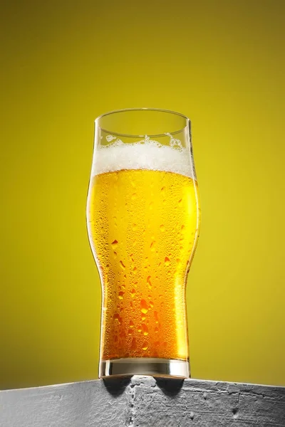 Bardak soğuk köpüklü lager bira eski ahşap masa — Stok fotoğraf