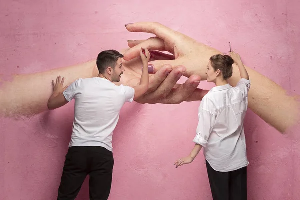 El collage sobre la pareja escribiendo algo en una pared rosa — Foto de Stock