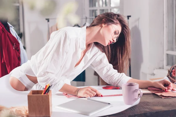 Diseñadores de moda trabajando en el estudio sentados en el escritorio — Foto de Stock