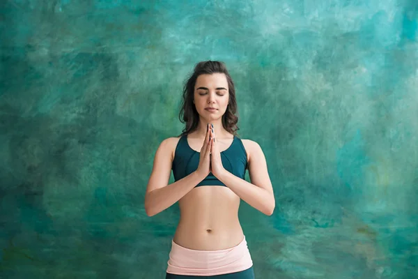 Estúdio tiro de uma jovem mulher fazendo exercícios de ioga em fundo verde — Fotografia de Stock