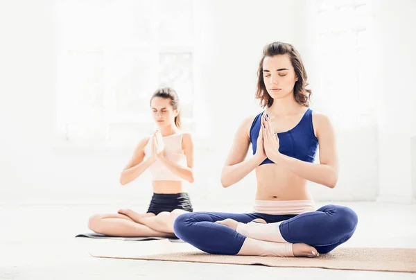 Estúdio tiro de uma jovem mulheres fazendo exercícios de ioga no fundo branco — Fotografia de Stock