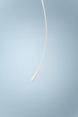 Splash süt veya krema üzerinde mavi arka plan izole