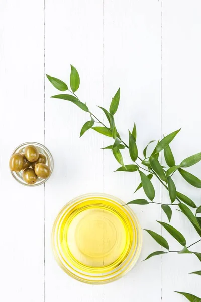 Olive oil and olive branch on the wooden table — Stock Photo, Image