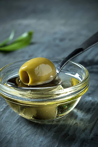 Olive oil and olive branch on the wooden table — Stock Photo, Image