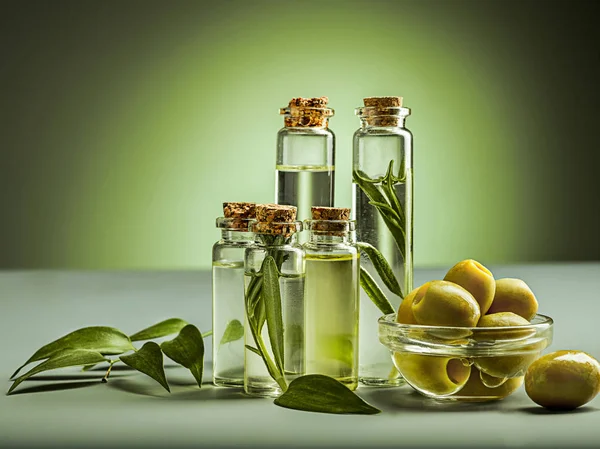 Olive oil and olive branch on the wooden table — Stock Photo, Image