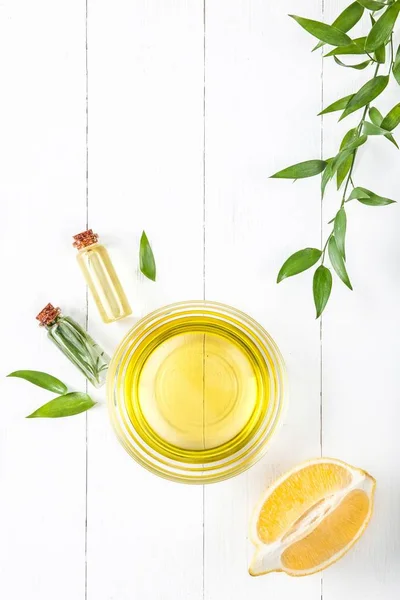 Lemon oil isolated on white wooden table — Stock Photo, Image