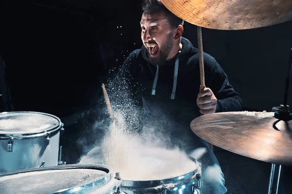 Drummer rehearsing on drums before rock concert. Man recording music on drum set in studio