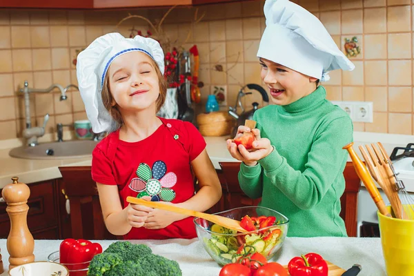 Счастливая семья забавные дети готовят свежий овощной салат на кухне — стоковое фото