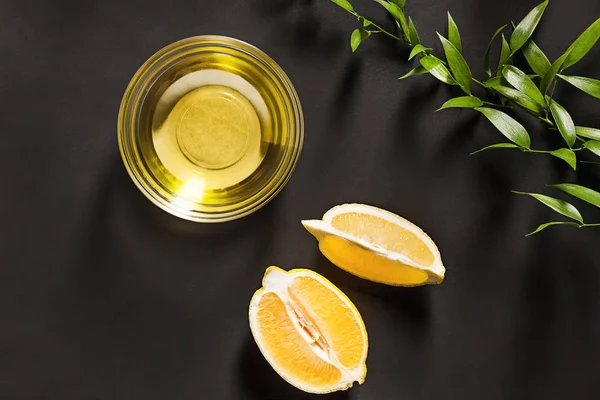 Lemon oil isolated on black table — Stock Photo, Image