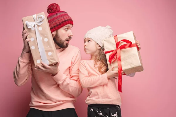 Портрет удивленной маленькой девочки с отцом, держащим рождественский подарок — стоковое фото