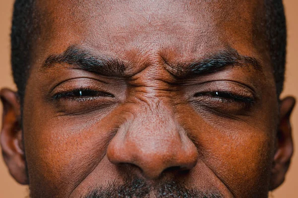 O piscar de olhos de homem afro-americano elegante na parede do estúdio marrom — Fotografia de Stock