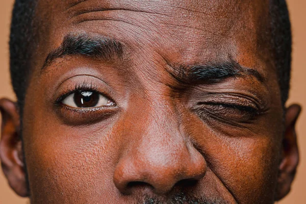 El guiño del hombre afro americano con estilo en la pared del estudio marrón — Foto de Stock