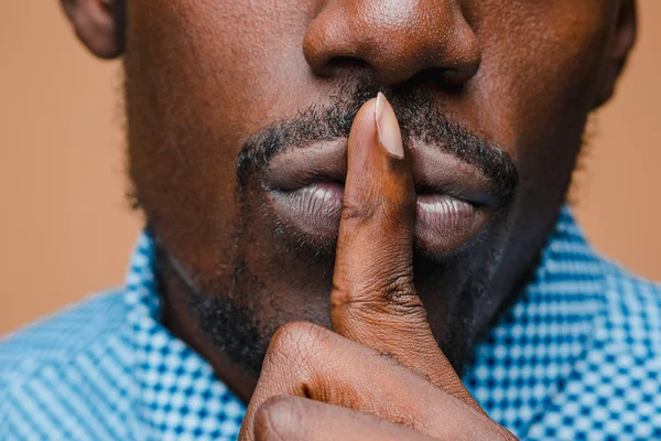 Black businessman calls on the silent, isolated on brown background — Stock Photo, Image