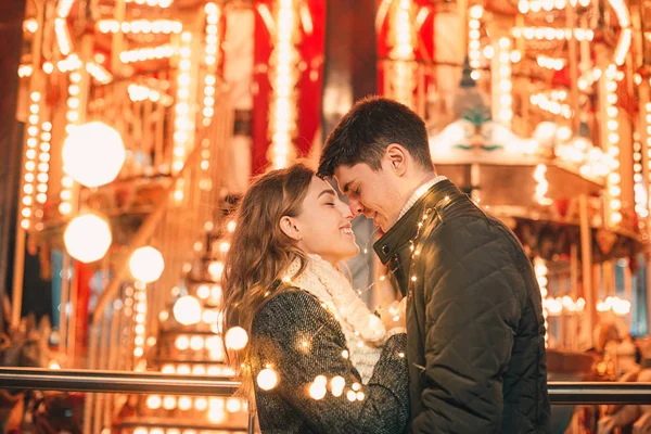 Pareja joven besándose y abrazándose al aire libre en la calle de la noche en Navidad —  Fotos de Stock