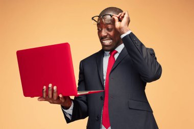 Oturma ve bir dizüstü bilgisayar kullanarak Afro Amerikan yakışıklı