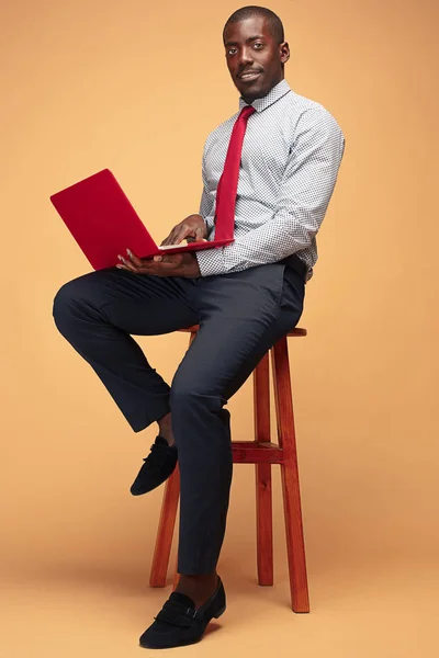 Hombre afroamericano guapo sentado y usando una computadora portátil —  Fotos de Stock