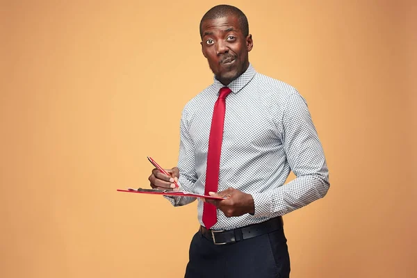 Attractive standing Afro-American businessman writing notes — Stock Photo, Image