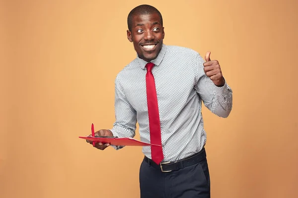 Attractive standing Afro-American businessman writing notes — Stock Photo, Image