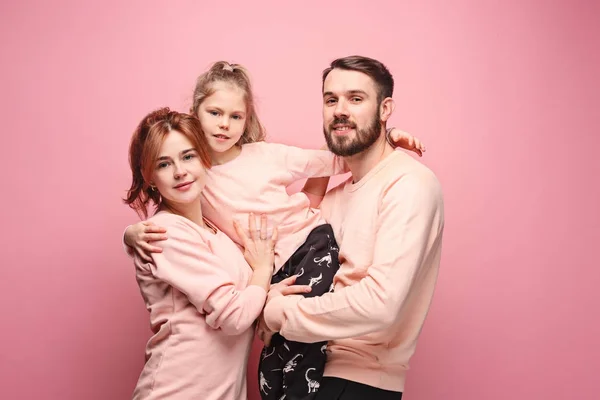 Feliz familia joven con una pequeña hija posando juntos — Foto de Stock