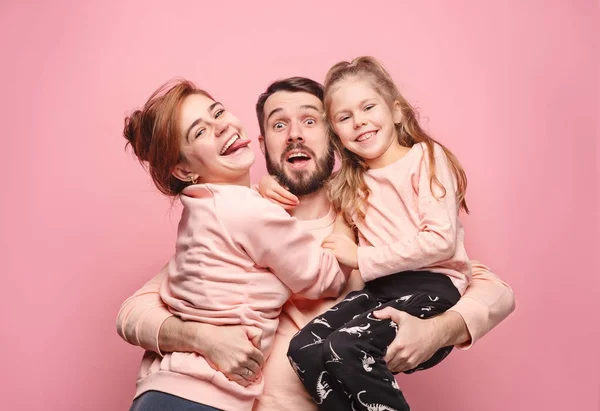 Feliz familia joven con una pequeña hija posando juntos — Foto de Stock