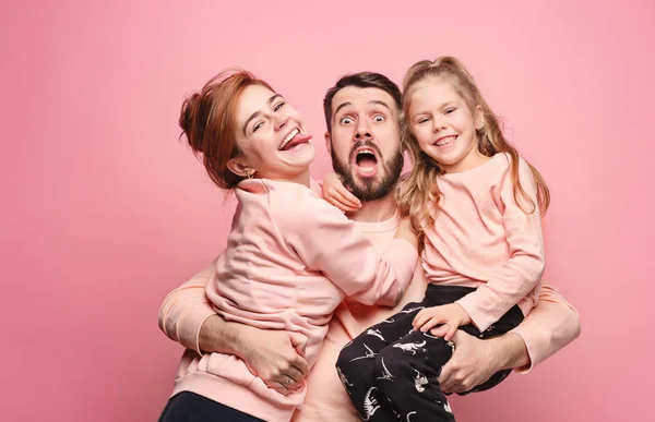 Feliz jovem família com uma pequena filha posando juntos — Fotografia de Stock