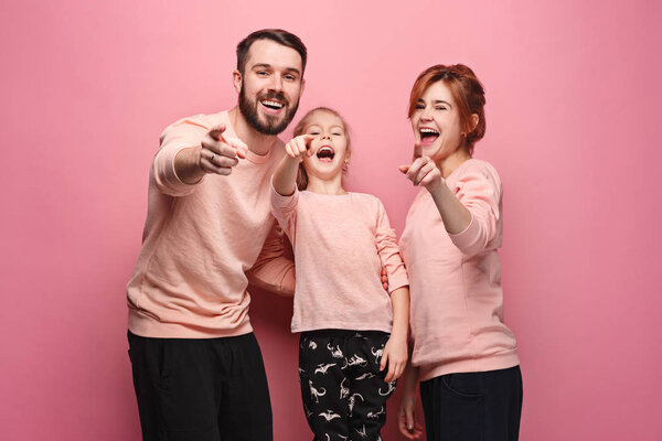 Surprised young family on pink