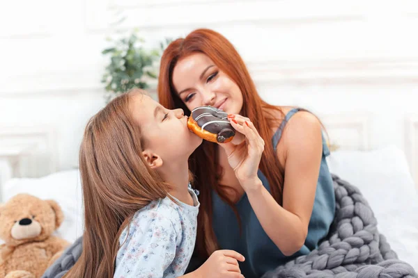 Une petite fille mignonne profiter, jouer et créer avec le gâteau avec la mère — Photo