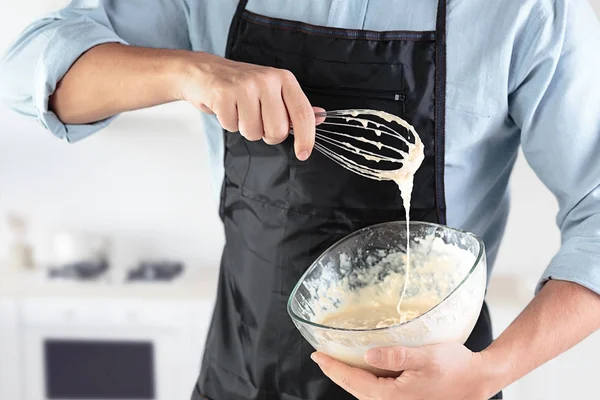 A cook with eggs on a rustic kitchen against the background of mens hands