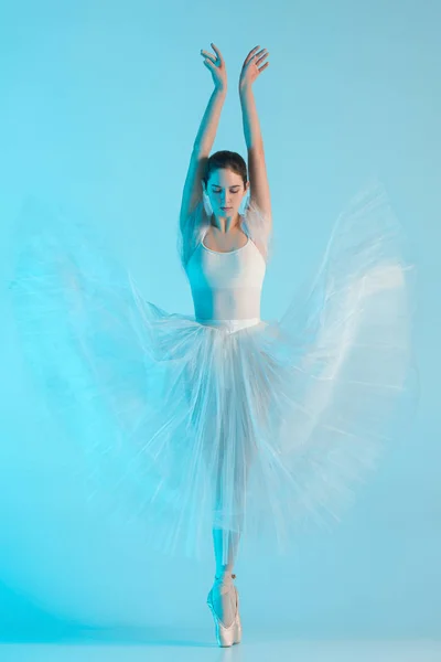 Молодая и невероятно красивая балерина танцует в голубой студии — стоковое фото