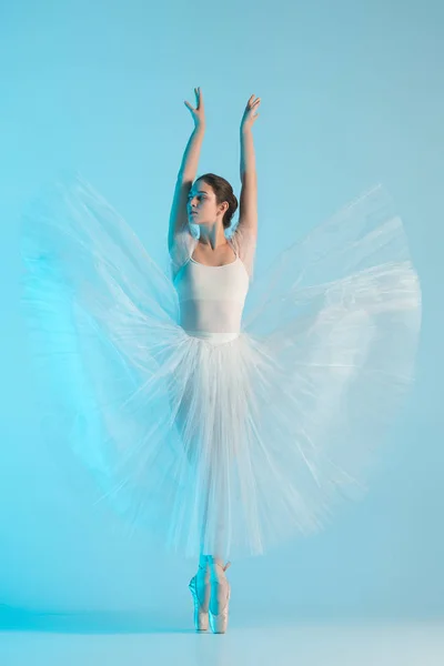 Jonge en ongelooflijk mooie ballerina is dansen in een blauwe studio — Stockfoto