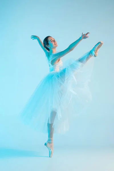 Jovem e incrivelmente bela bailarina está dançando em um estúdio azul — Fotografia de Stock