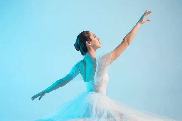 Молодая и невероятно красивая балерина танцует в голубой студии — стоковое фото